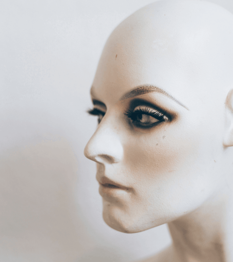 AI against fashion counterfeits showcased on a mannequin head with striking makeup and lashes.