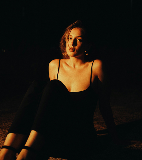 Celebrity in a dark setting wearing a gala gown, symbolising fashion’s afterlife and sustainability.