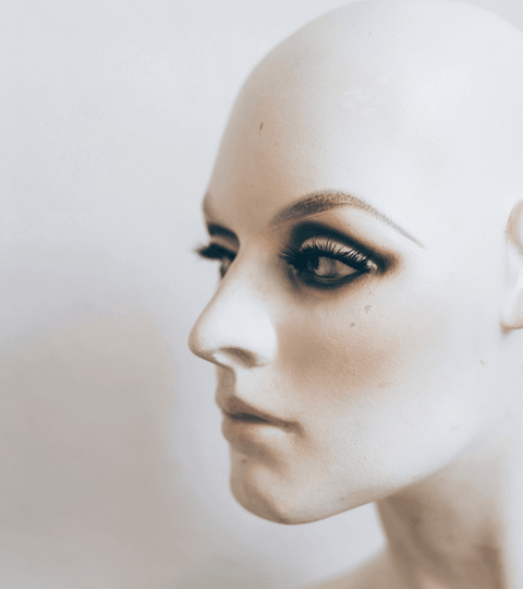 AI against fashion counterfeits showcased on a mannequin head with striking makeup and lashes.