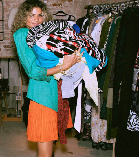 This Is Where You Can Buy The Best Vintage in London: woman shopping with vintage clothes in a trendy boutique.