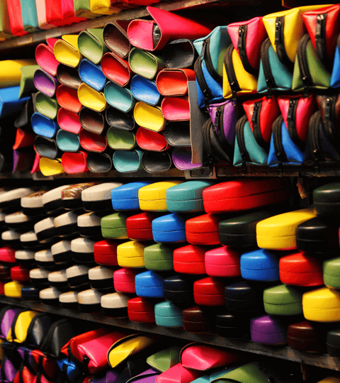 Colorful leather rolls stacked in a store, showcasing the variety in leather in high fashion.