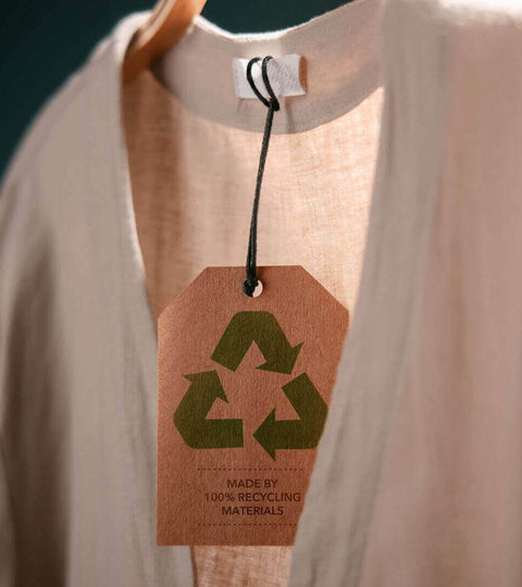 Shirt on a hanger with a recycling tag representing fabric circularity in fashion