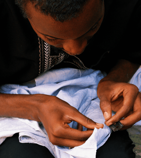 A person repairing fabric, highlighting the theme of how to fix and love your clothes.