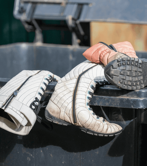 Is Donating Your Old Clothes Good or Bad for the Environment: discarded shoes in a recycling bin.