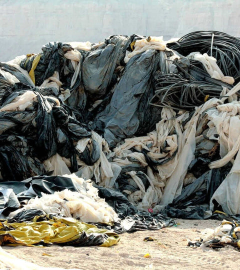 piles of discarded plastic and fabric waste representing what happens to donated clothes in the fashion industry