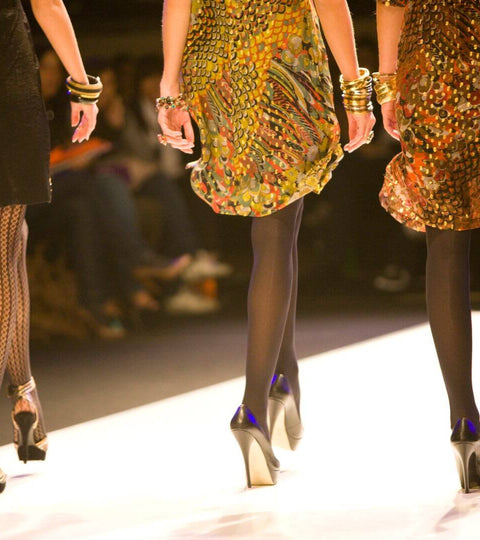 Models walking the runway in vibrant dresses at Fashion Week, showcasing the latest trends.