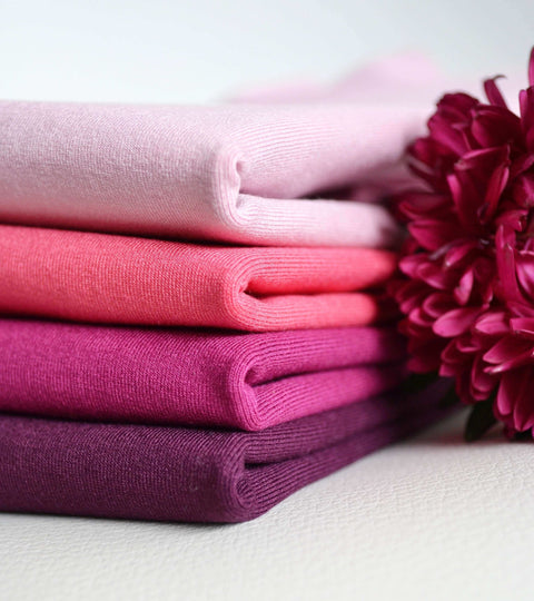 Vibrant hues of wool fabrics showcasing sustainable wool innovation with a flower accent added for style.