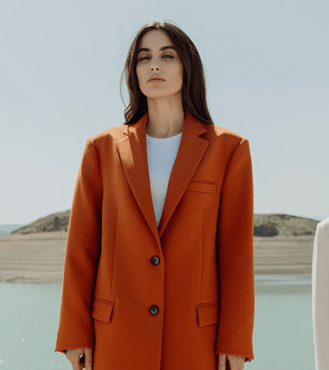 Three fashion figures, including a central figure in red, illustrating the fashion industry waste problem