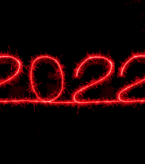 2022 written in glowing red sparks against a black background, symbolizing celebration and new beginnings.