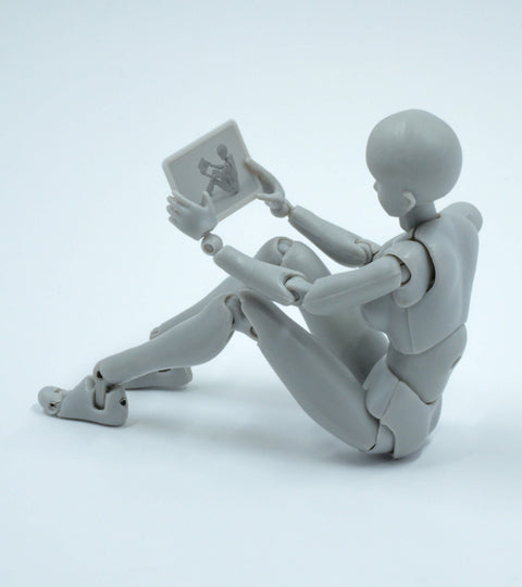 Gray mannequin sitting and holding a tablet, representing digital human stylists in sustainable wardrobe tech.